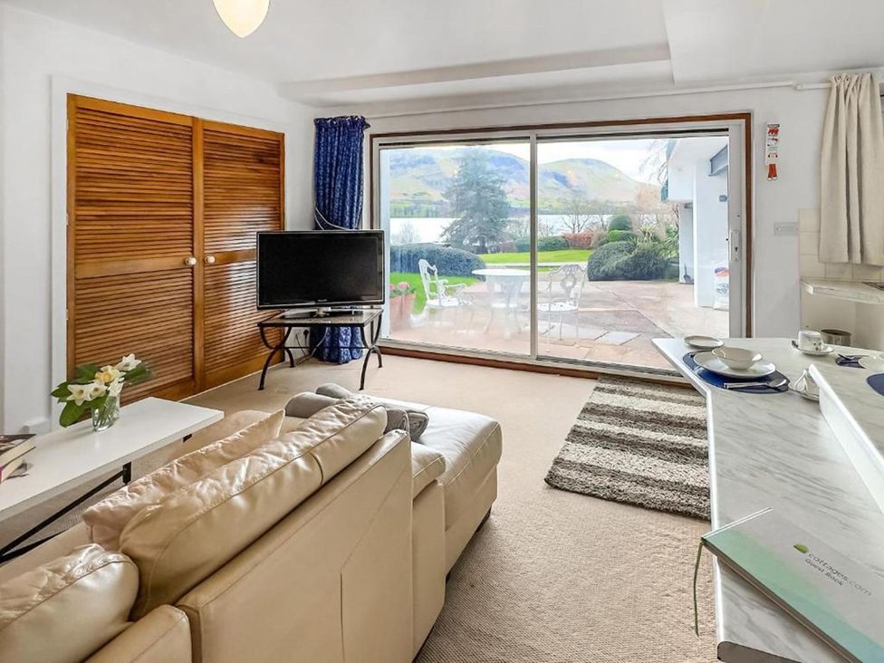 A living room with a sliding door and television at Apartment Sleeps 2 with Parking, Pets Welcome in Watermillock near Pooley Bridge
