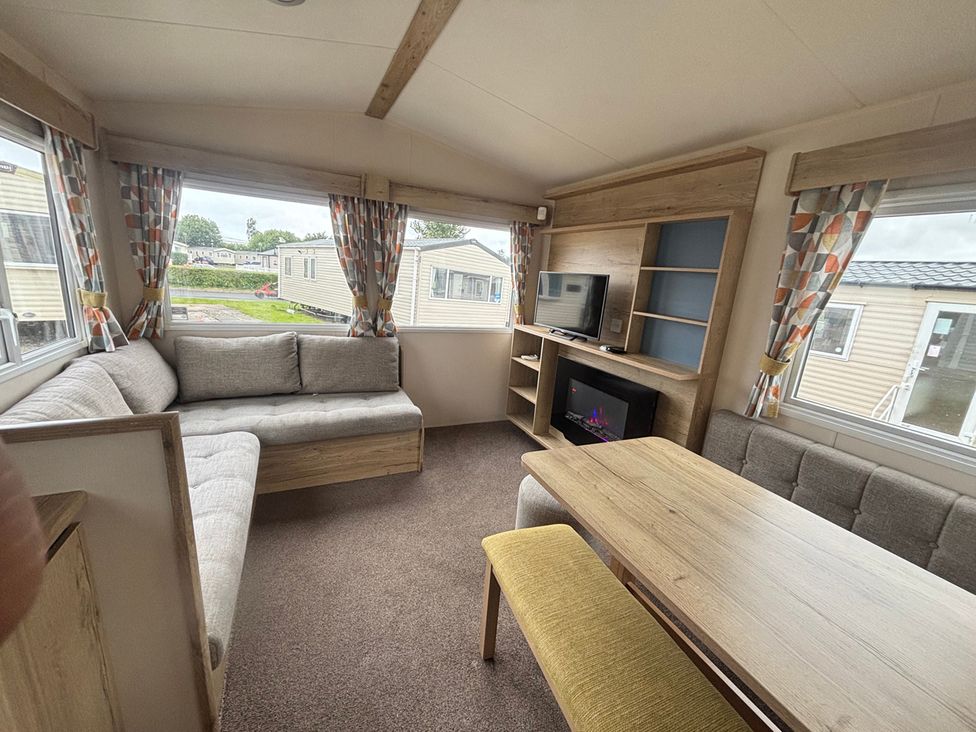A living room with a sofa and table at Caravan Sleeps 5 - Decking, Parking, Pet Friendly in Blackpool