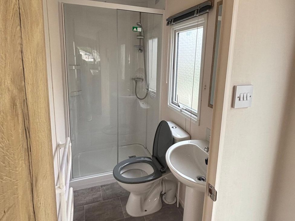A bathroom with a shower, toilet, and sink at Caravan Sleeps 5 - Decking, Parking, Pet Friendly, Blackpool