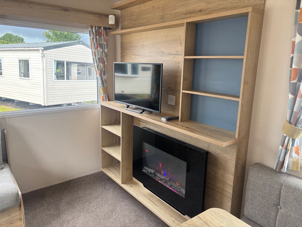 A living room with a TV and fireplace at Caravan Sleeps 5 - Decking, Parking, Pet Friendly in Blackpool