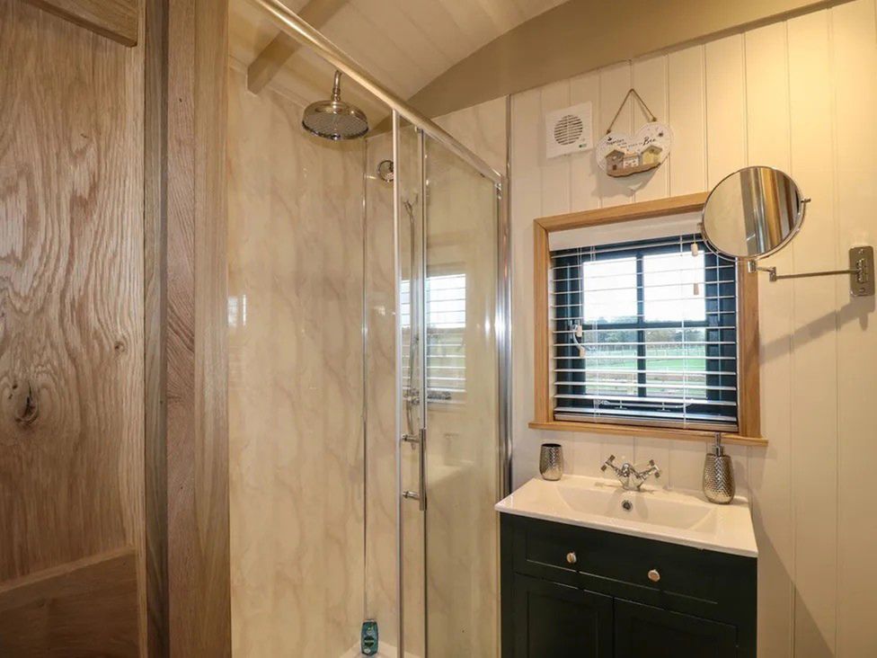 A bathroom with a shower and sink at Shepherd's Hut- Hot Tub- Wellness Spa- Wood Burner Nottingham