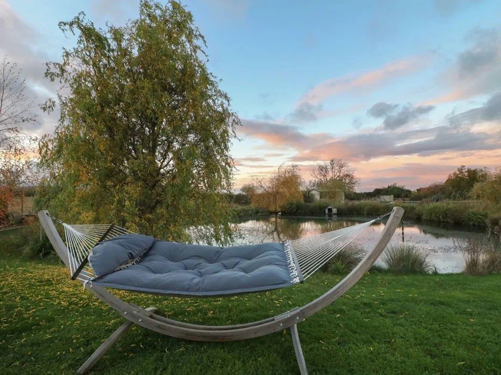 A hammock near a pond at Shepherd's Hut- Hot Tub- Wellness Spa- Wood Burner Nottingham
