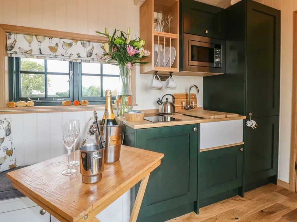A kitchen with a sink and kettle at Shepherd's Hut- Hot Tub- Wellness Spa- Wood Burner Nottingham