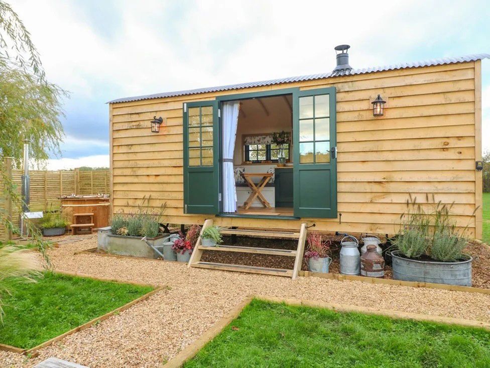 An outdoor view of a cabin with steps and garden features at Shepherd's Hut- Hot Tub- Wellness Spa- Wood Burner Nottingham