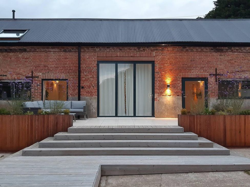 An exterior view of a property with sliding doors and outdoor seating at Simple Coastal Luxury near Southwold