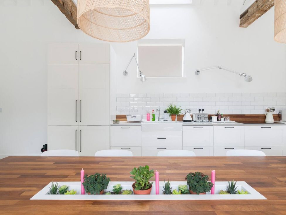 A kitchen with wooden table and plants at Simple Coastal Luxury near Southwold sleeps 10 Near Southwold