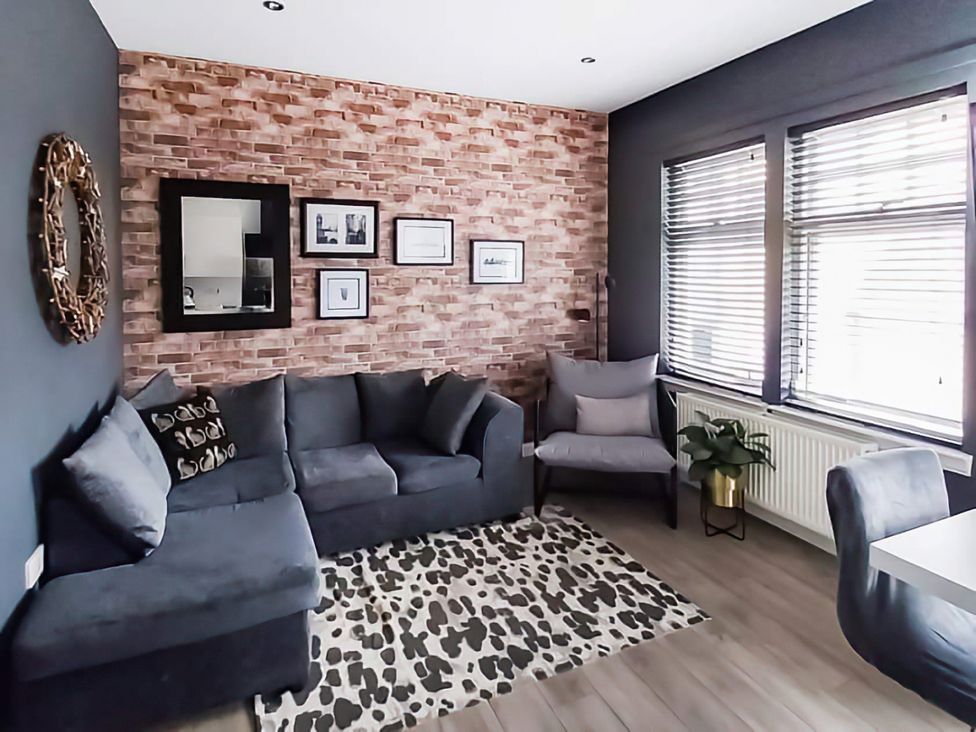 A living room with a sofa and a table at Modern Apartment - Sleeps 4 - Centrally located, Lanark