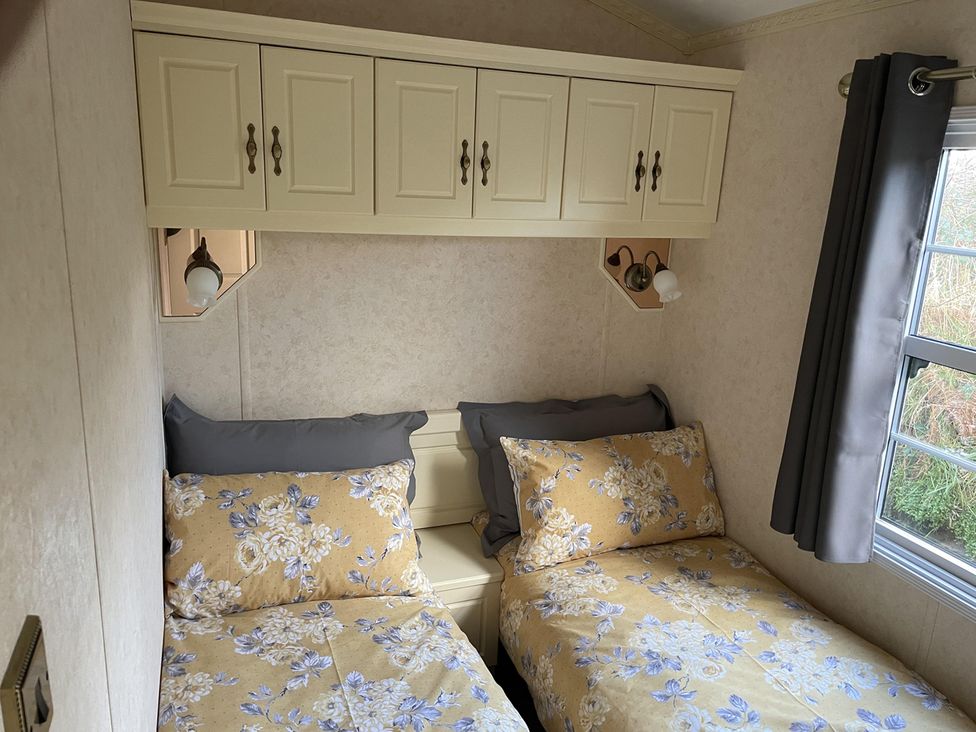 A bedroom with two beds and cabinets at Chalet Sleeps 4 Near Cymyran Beach in Caergeiliog