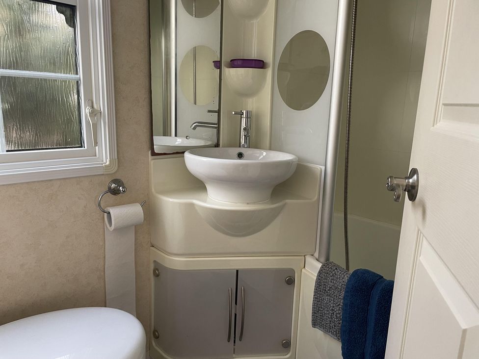 A bathroom with a sink and toilet at Chalet Sleeps 4 Near Cymyran Beach Caergeiliog