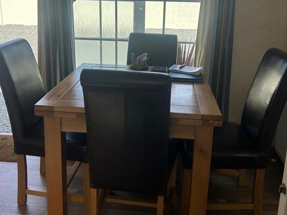 A dining room with a table and chairs at Chalet Sleeps 4 Near Cymyran Beach Caergeiliog