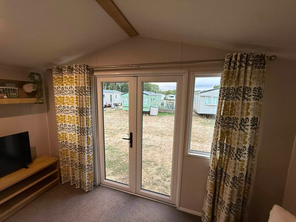 A living room with a television and curtains at Billing Aquadrome Holiday Park - 2 Bedroom, Silver, Northampton