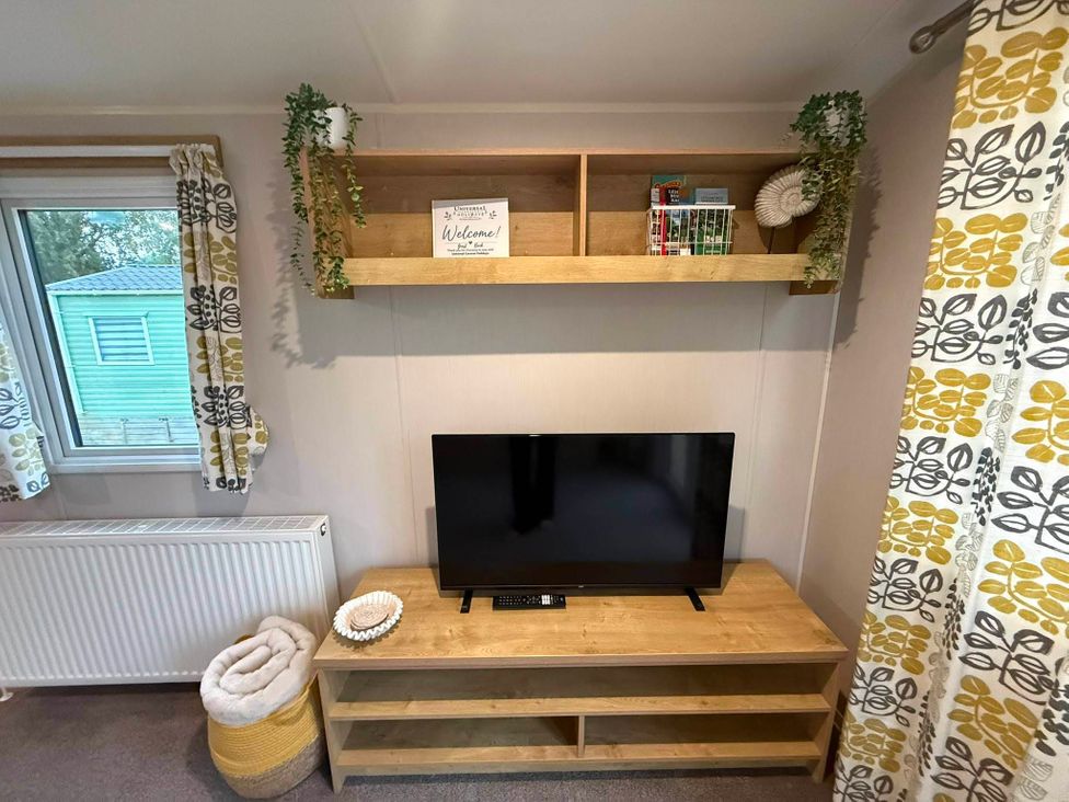 A living room with a television and shelf at Billing Aquadrome Holiday Park - 2 Bedroom, Silver in Northampton