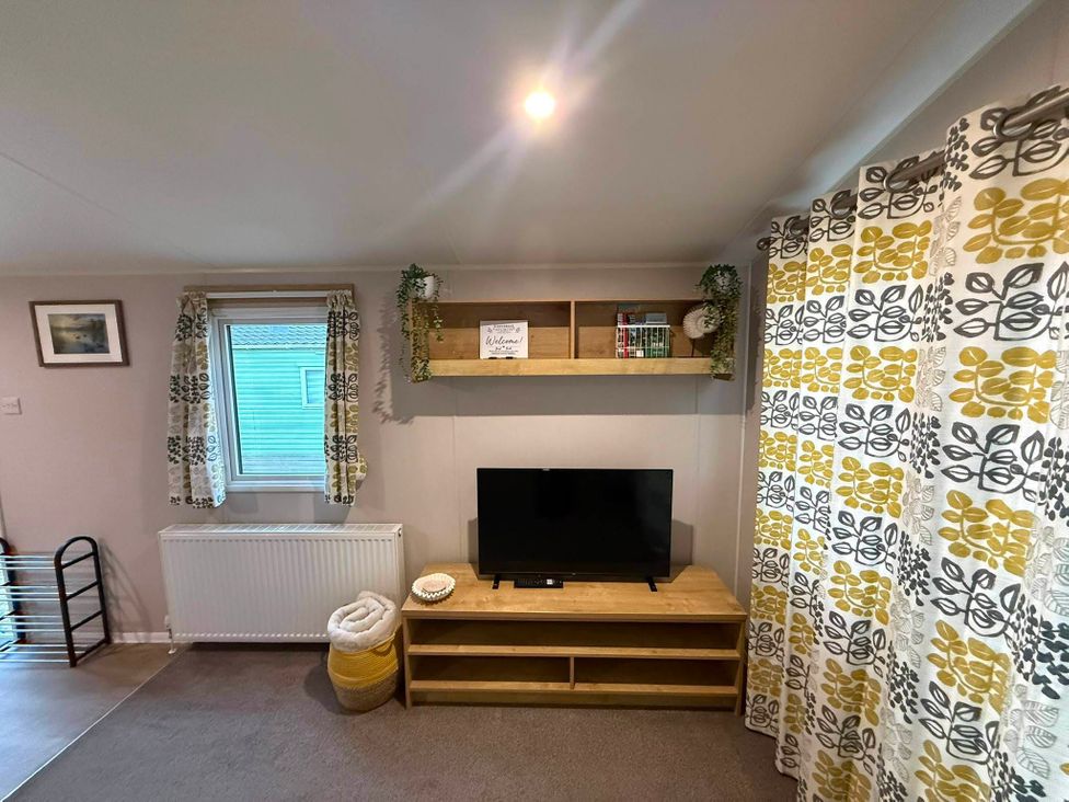 A living room with a television and shelf at Billing Aquadrome Holiday Park - 2 Bedroom, Silver in Northampton