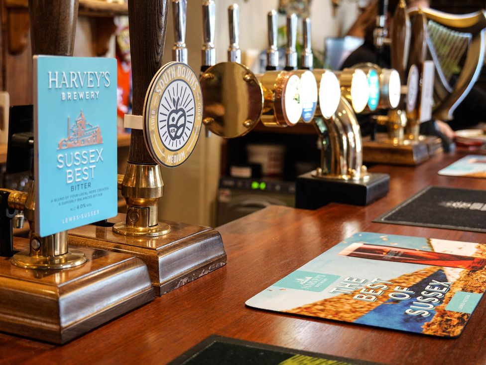 A bar with beer taps and drink menus at Royal Oak Retreat Sleeps 6 Pub Pet Friendly Barcombe Cross