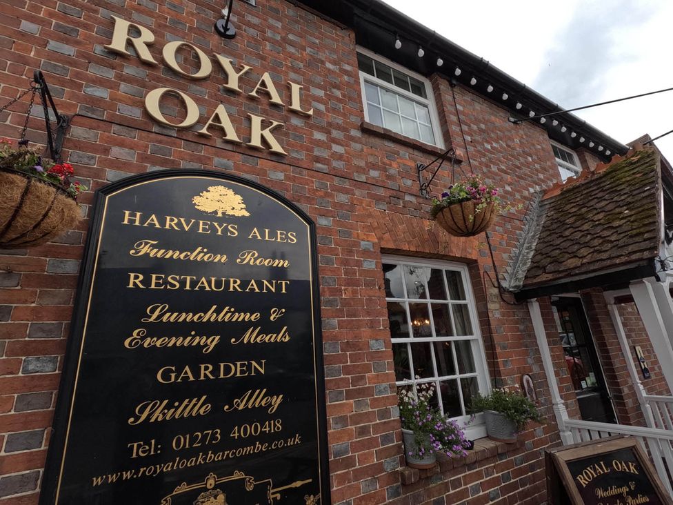 The exterior of Royal Oak with a sign displaying services at Royal Oak Retreat Sleeps 6 Pub Pet Friendly Barcombe Cross