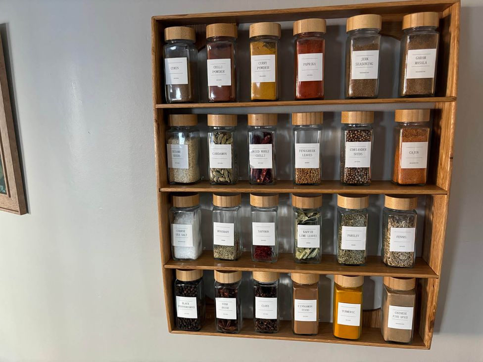 A spice rack with labeled jars containing various spices at Royal Oak Retreat Sleeps 6 Pub Pet Friendly Barcombe Cross