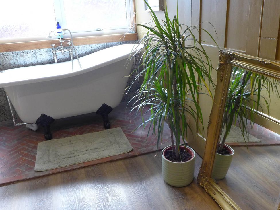 A bathroom with a bathtub and plants at Royal Oak Retreat Sleeps 6 Pub Pet Friendly, Barcombe Cross