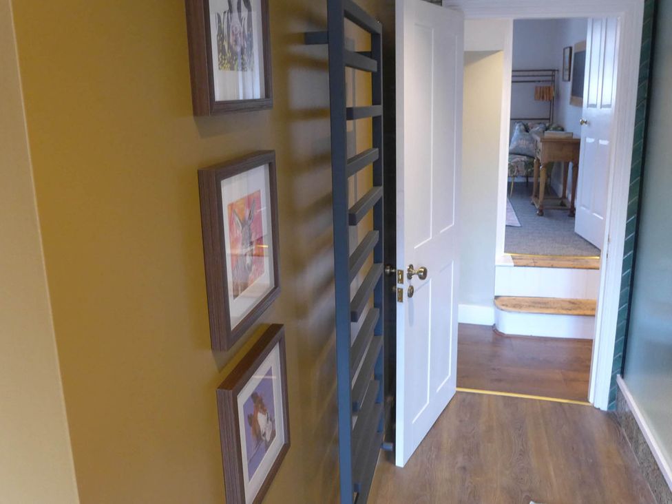 A hallway with pictures on a wall and a door leading to another room at Royal Oak Retreat Sleeps 6 Pub Pet Friendly Barcombe Cross