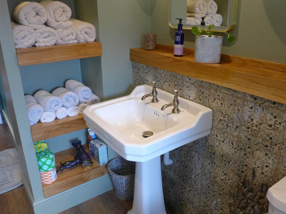 A sink and shelving with towels at Royal Oak Retreat Sleeps 6 Pub Pet Friendly Barcombe Cross