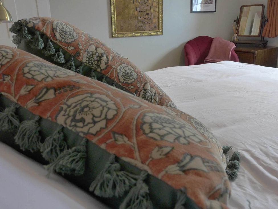 A bedroom with decorative pillows and a chair at Royal Oak Retreat Sleeps 6 Pub Pet Friendly, Barcombe Cross