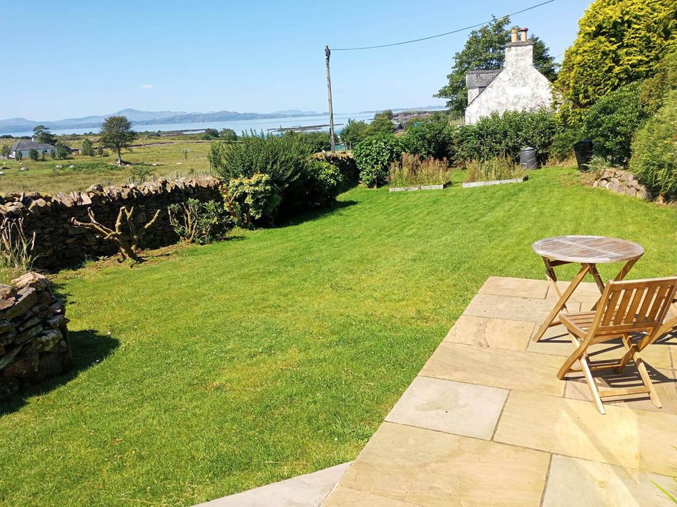A garden with a patio, table, and chair at Marsco Apartment Garden Patio Sea Views Applecross near Lochcarron