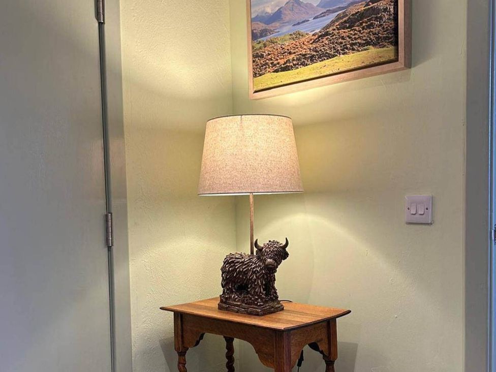 A side table with a lamp and picture at Marsco Apartment Garden Patio Sea Views Applecross near Lochcarron