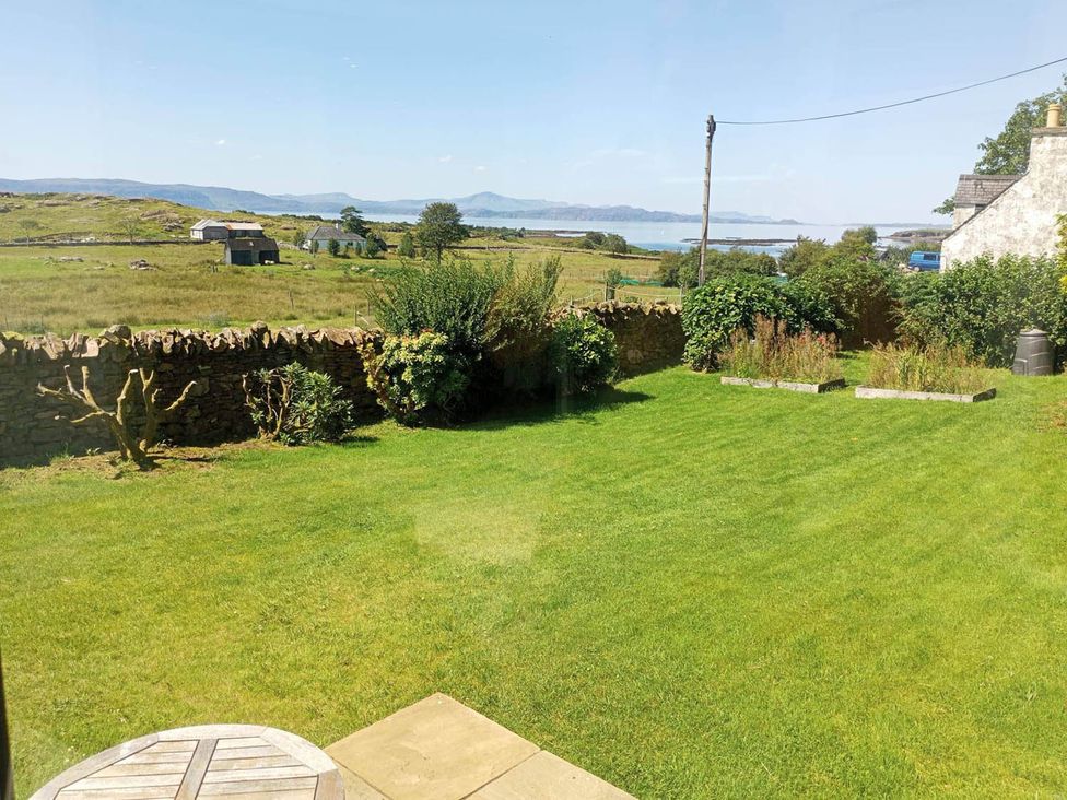 A garden with grass and a stone wall at Marsco Apartment Garden Patio Sea Views Applecross near Lochcarron