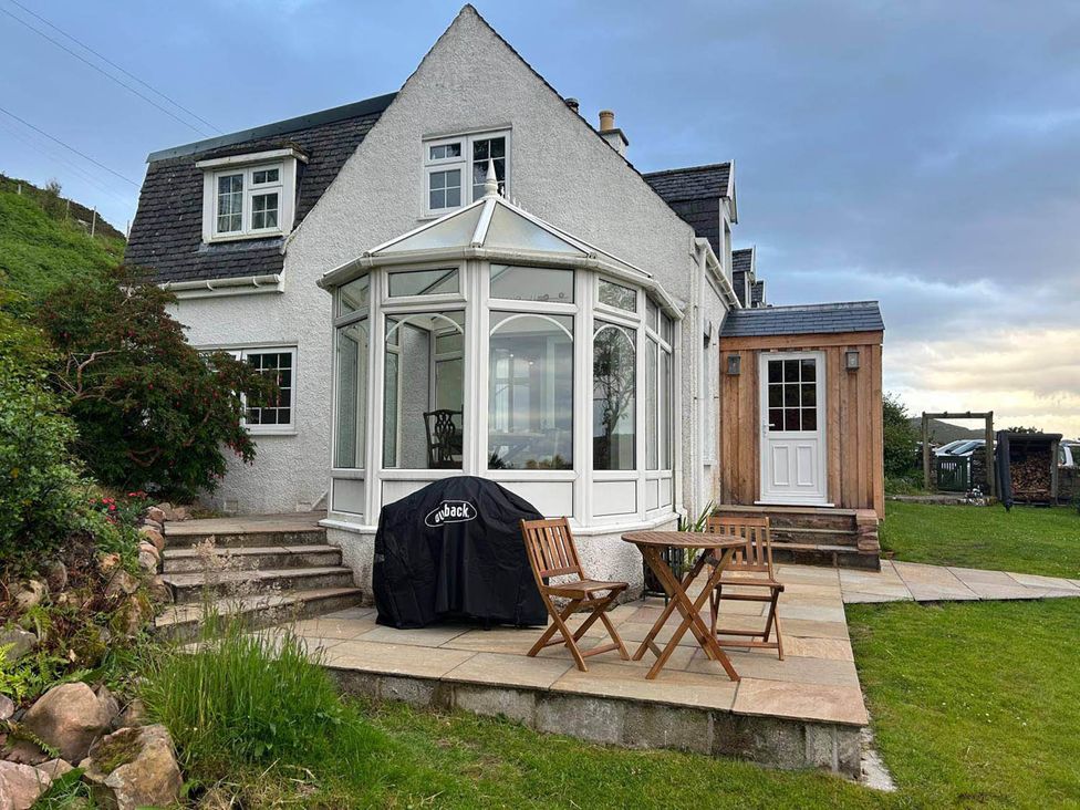 A house with a conservatory and outdoor seating area at Marsco Apartment Garden Patio Sea Views Applecross near Lochcarron