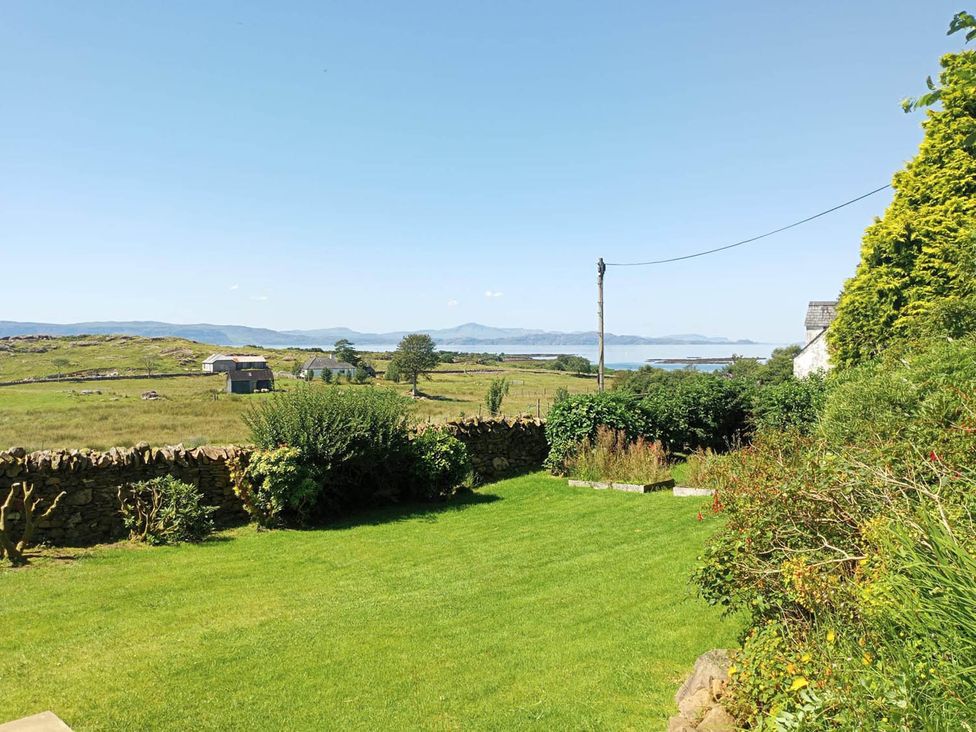 A garden view with grass and stone wall at Marsco Apartment Garden Patio Sea Views in Applecross near Lochcarron
