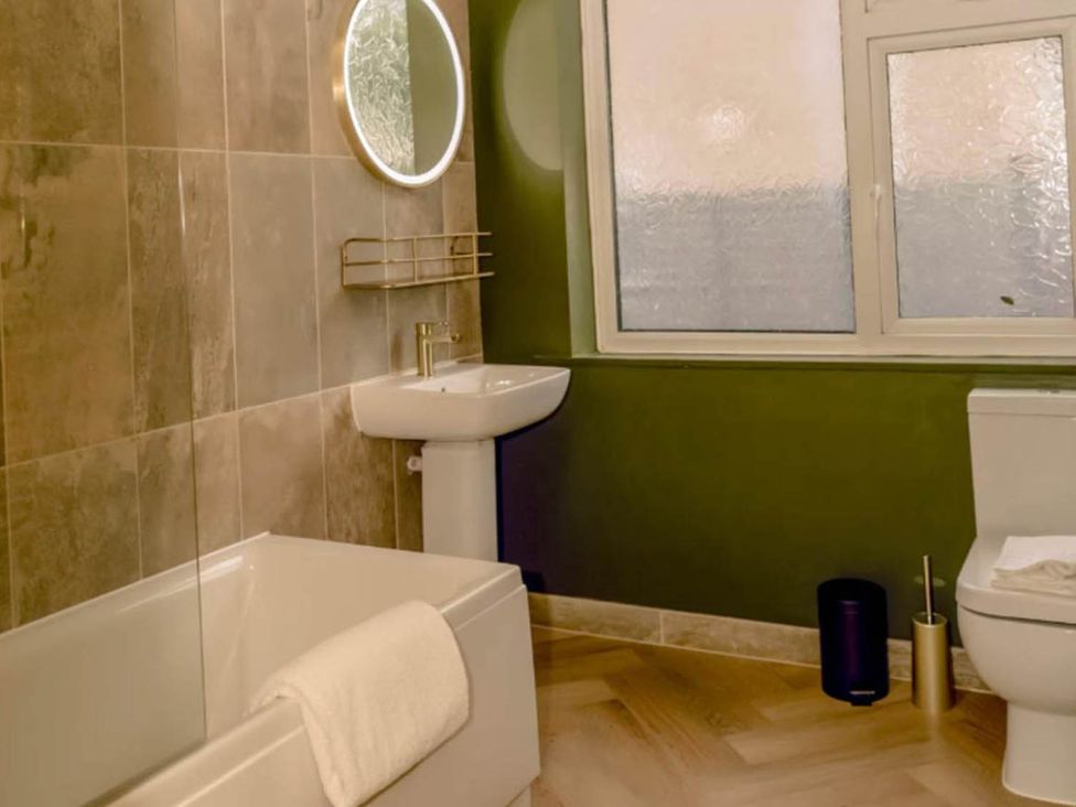 A bathroom with a bathtub, sink, and toilet at 2 Bedroom Apartment Sleeps 3 - Garden - Pets, Carbis Bay
