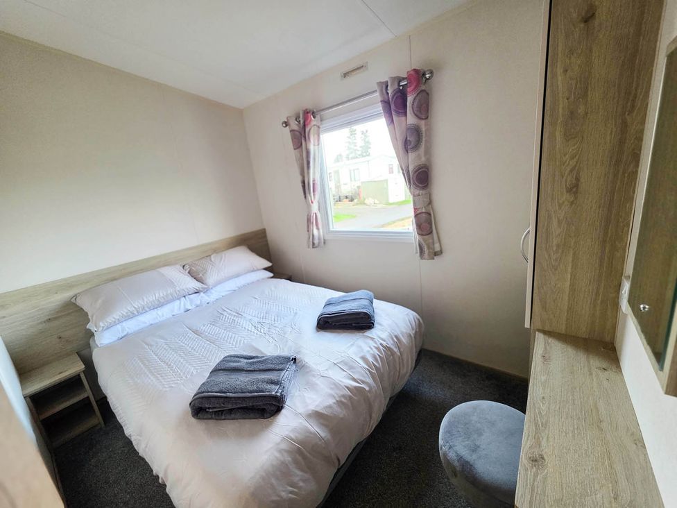 A bedroom with a bed and a window at Static Caravan 3 Bed Sleeps 8 Dog Friendly Parking Northampton