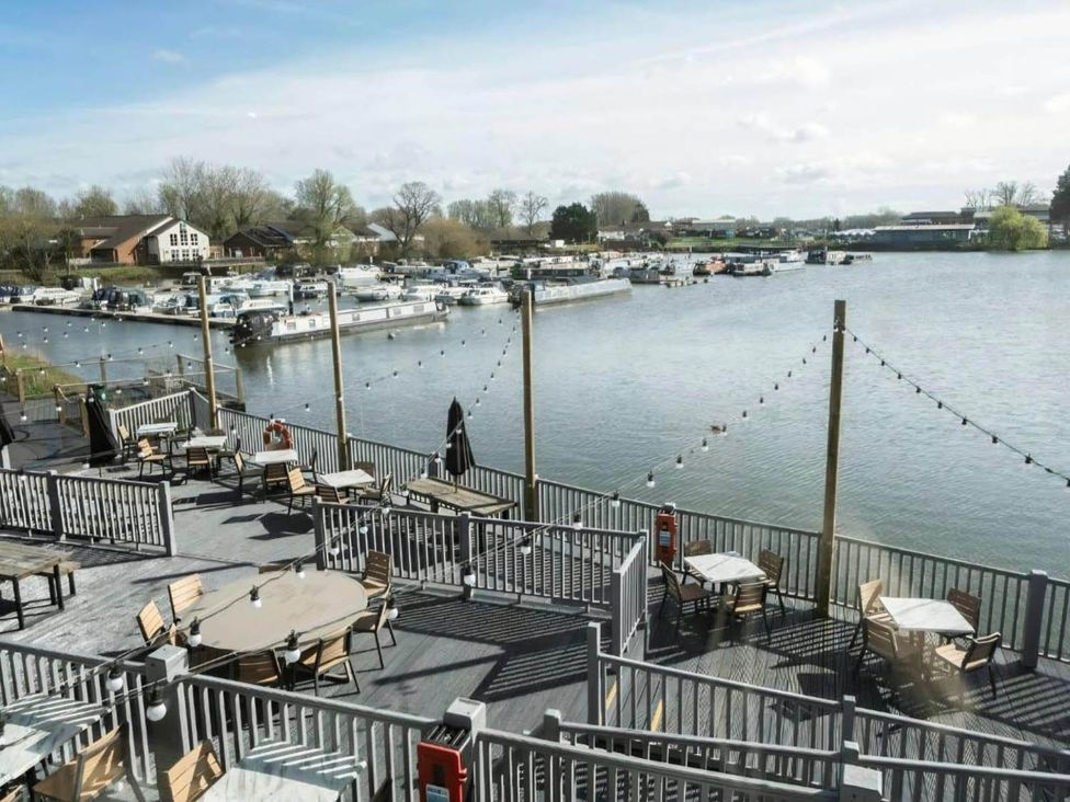An outdoor seating area overlooking water and boats at Static Caravan 3 Bed Sleeps 8 Dog Friendly Parking Northampton