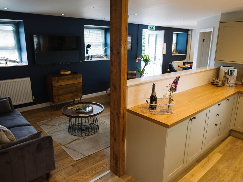 A living room with a sofa and television at Snowdon Studio Apartment in Tal-y-cafn near Llandudno Junction