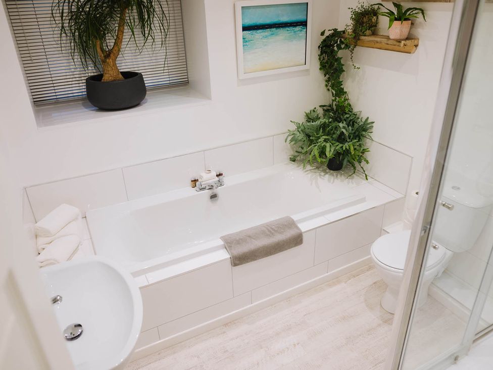 A bathroom with a bathtub, toilet, and sink at Snowdon Studio Apartment in Tal-y-cafn near Llandudno Junction