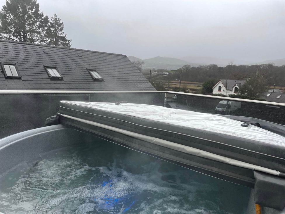 A hot tub with cover and steam in an outdoor area at Snowdon Studio Apartment in Tal-y-cafn near Llandudno Junction