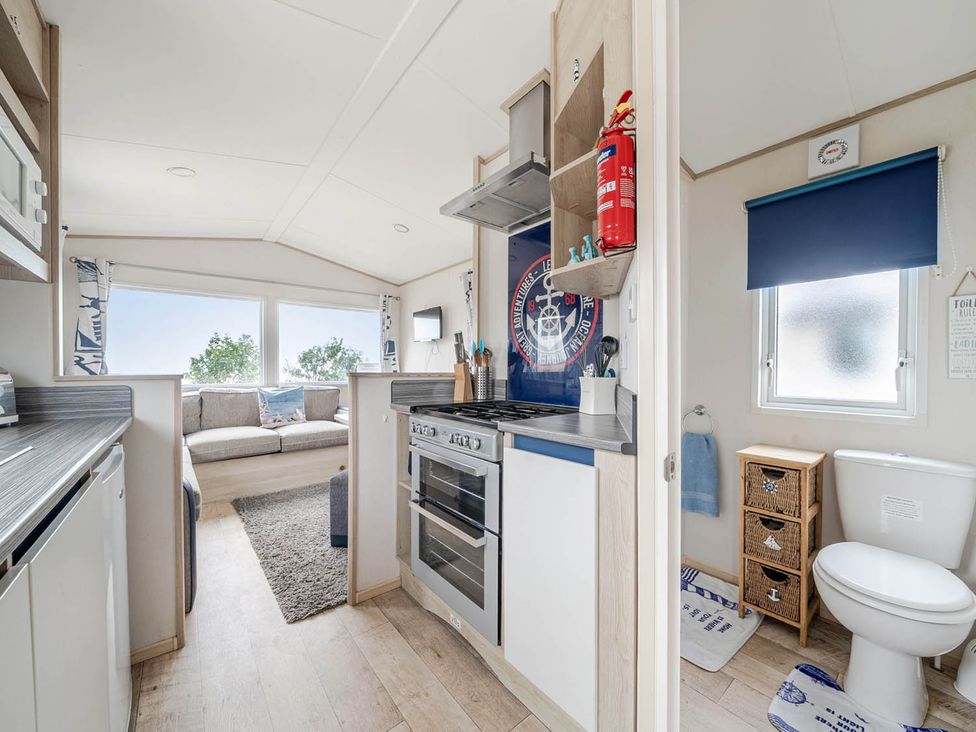 A kitchen with appliances and seating area at Cabin - Sleeps 4 - Pets Ok - Balcony - Parking in Haven Park, Doniford Bay near Watchet