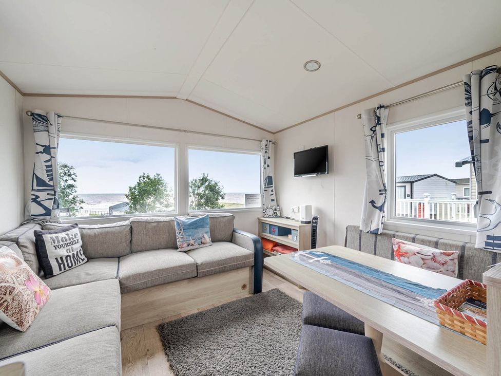 A living room with a sofa and a television at Cabin - Sleeps 4 - Pets Ok - Balcony - Parking Haven Park, Doniford Bay near Watchet