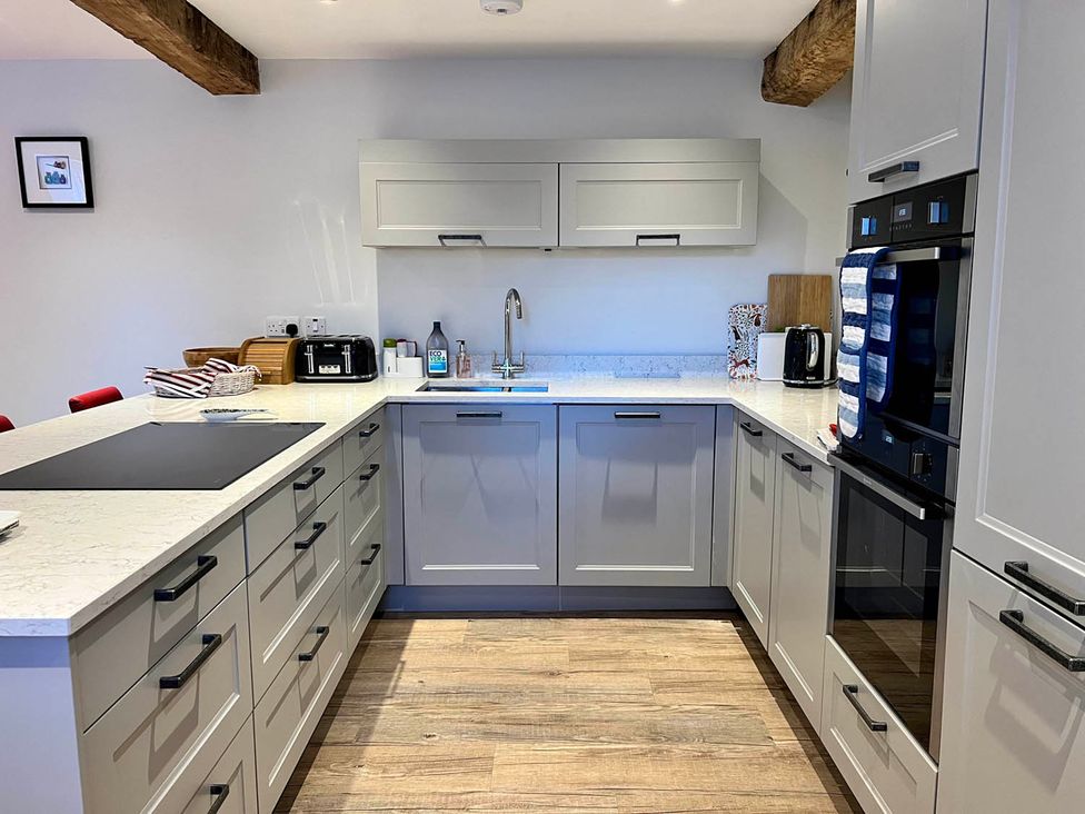 A kitchen with cabinets, countertop, and appliances at Cottage Sleeps 6 Garden Parking Beaulieu Farm near Coleford