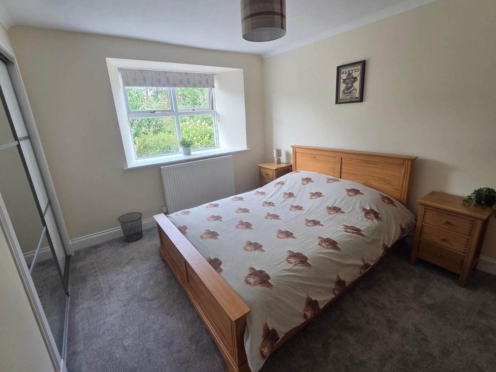 A bedroom with a bed and bedside tables at Farm Cottage at foot Angus Glens near Kirkton of Kingoldrum