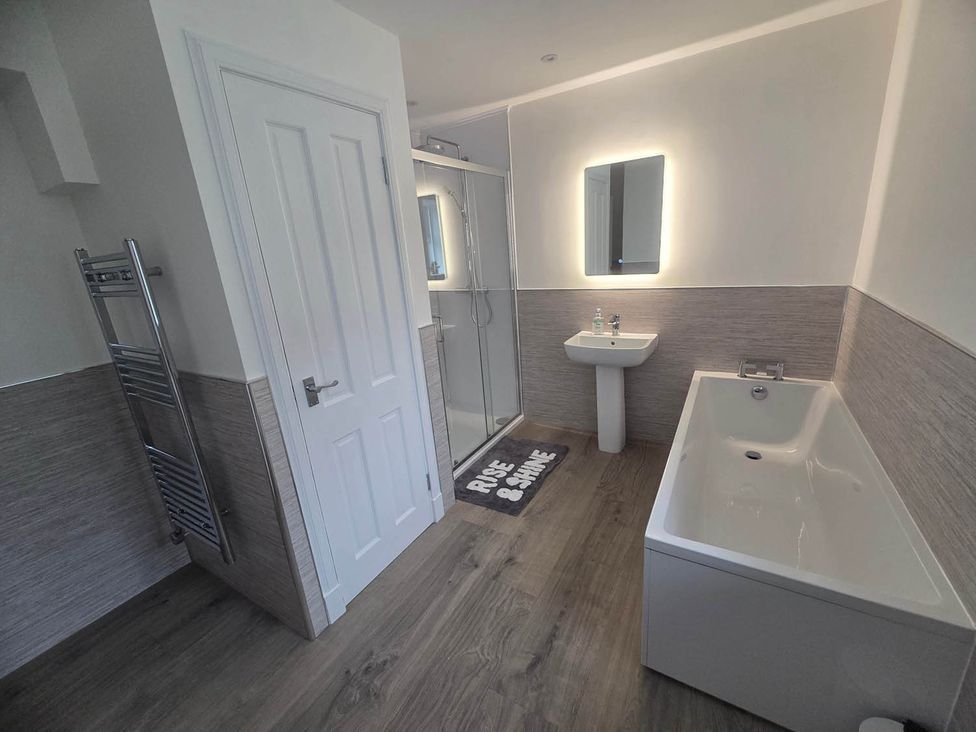 A bathroom with a bathtub, sink, and shower at Farm Cottage at foot Angus Glens near Kirkton of Kingoldrum