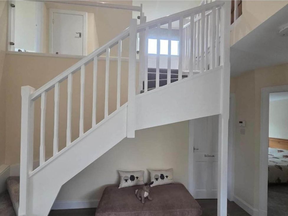 A staircase area with a handrail and a bench at Farm Cottage at foot Angus Glens in Kirkton of Kingoldrum near Kirriemuir