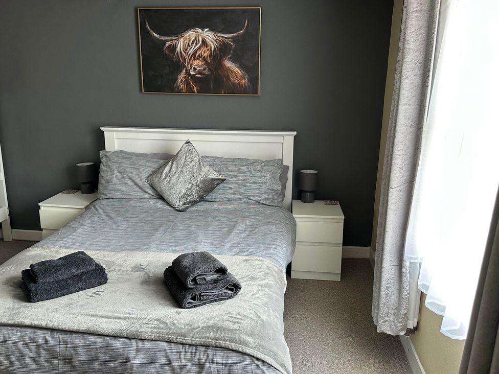 A bedroom with a bed and nightstand at Llanidloes - Sleeps 7 - Parking - Pet Friendly, Llanidloes