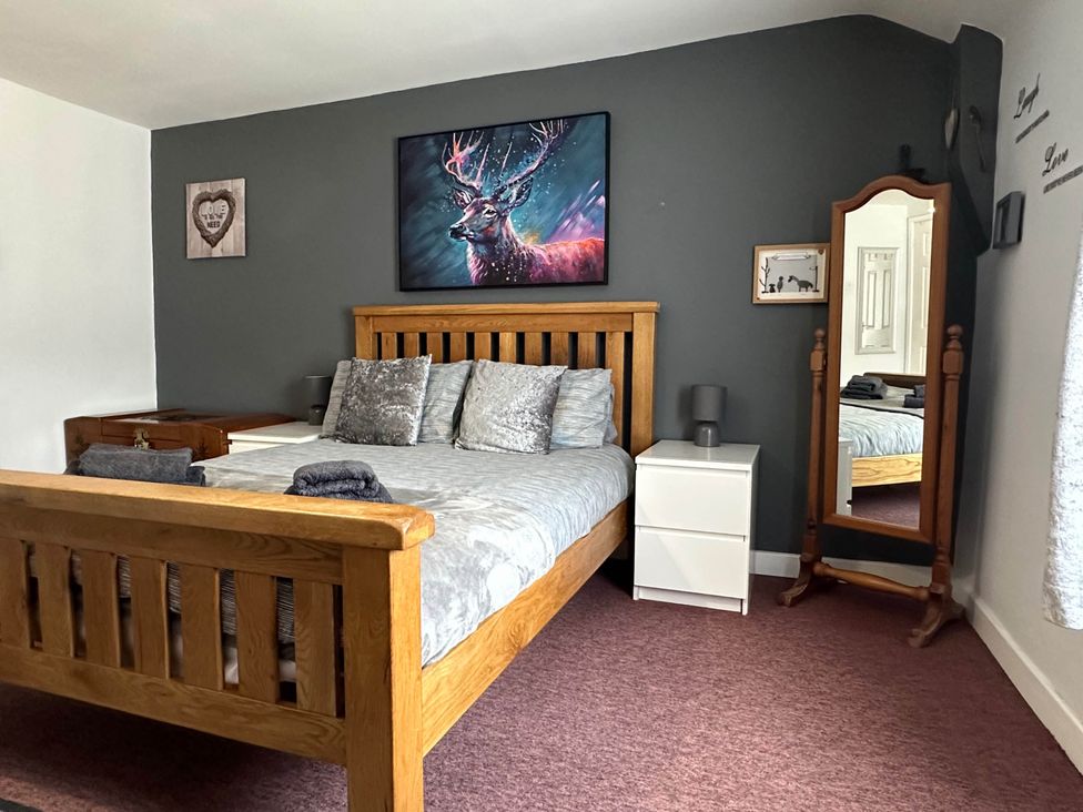 A bedroom with a bed and a mirror at Llanidloes - Sleeps 7 - Parking - Pet Friendly in Llanidloes