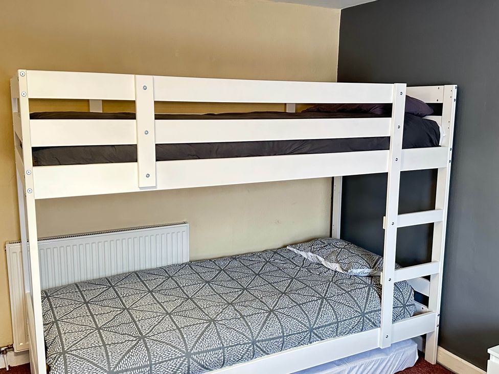 A bunk bed with a top and bottom mattress in a bedroom at Llanidloes - Sleeps 7 - Parking - Pet Friendly, Llanidloes