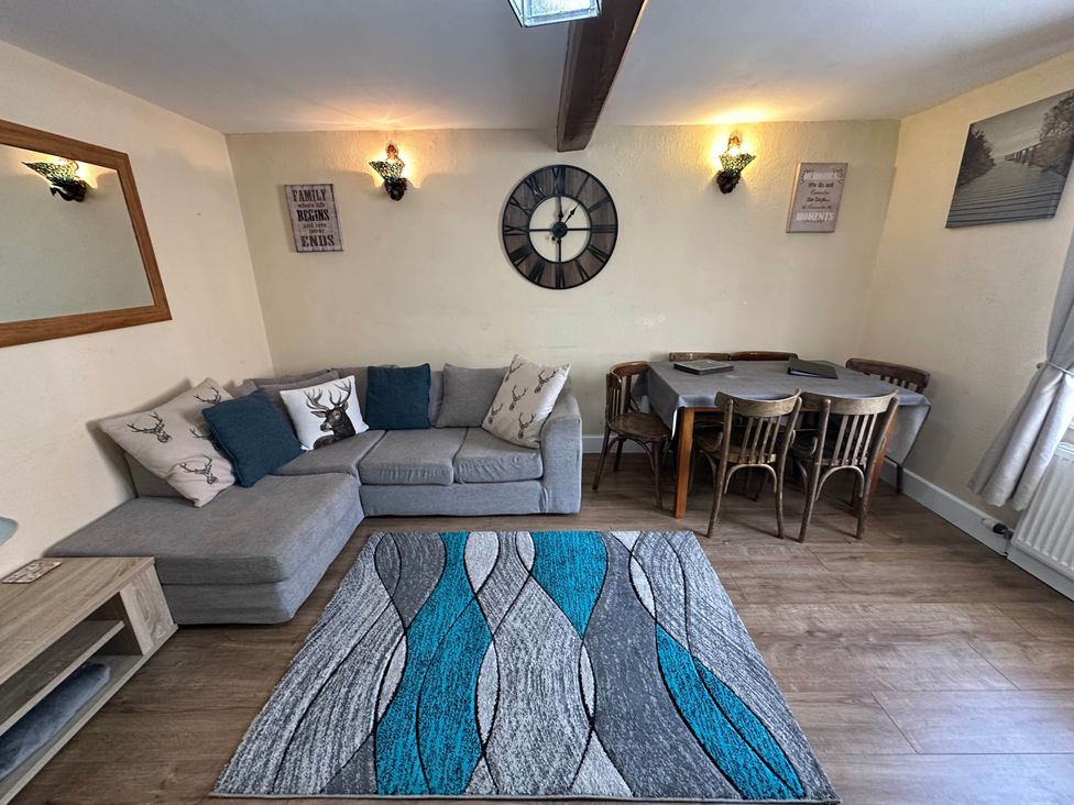 A living room with a sofa and dining table at Llanidloes - Sleeps 7 - Parking - Pet Friendly, Llanidloes
