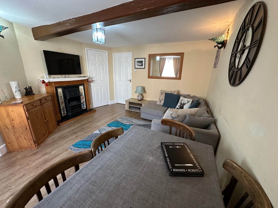 A living room with a sofa, dining table, and television at Llanidloes - Sleeps 7 - Parking - Pet Friendly, Llanidloes
