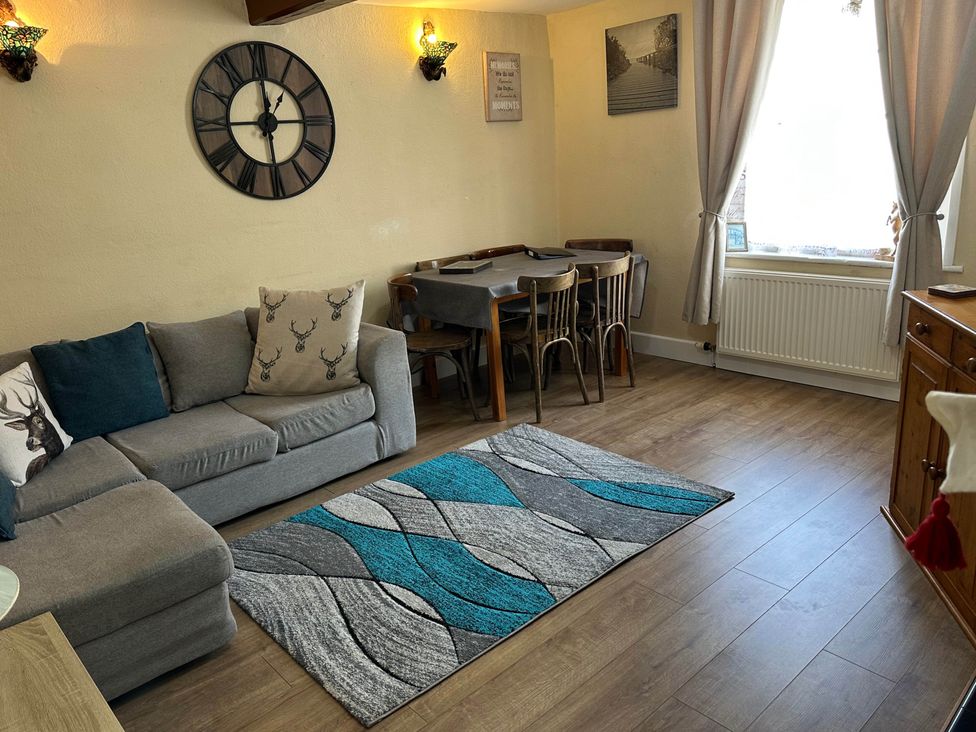 A living room with a clock and sofa at Llanidloes - Sleeps 7 - Parking - Pet Friendly, Llanidloes