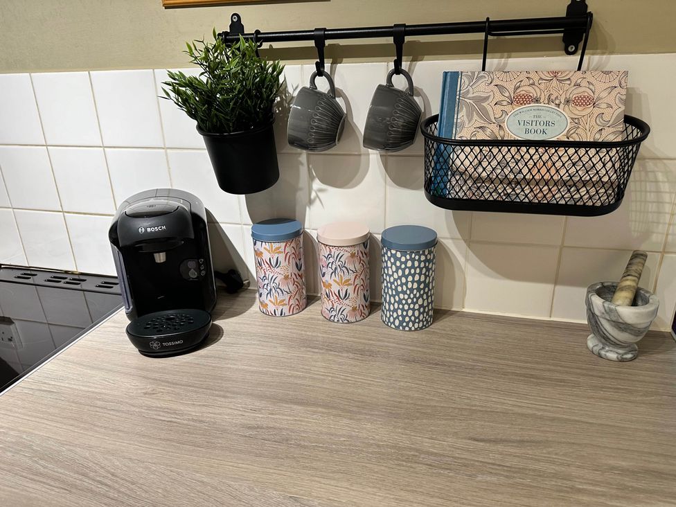 A kitchen with coffee machine, mugs, decorative containers and visitor's book at Llanidloes - Sleeps 7 - Parking - Pet Friendly, Llanidloes