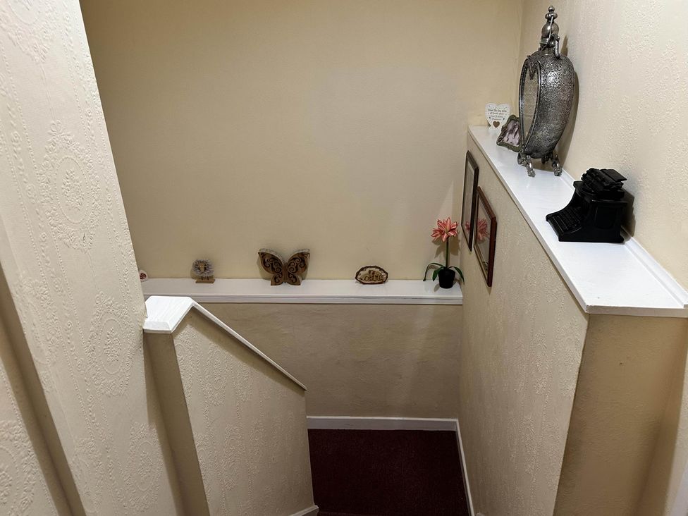 A stairway with decorative items on a shelf at Llanidloes - Sleeps 7 - Parking - Pet Friendly, Llanidloes