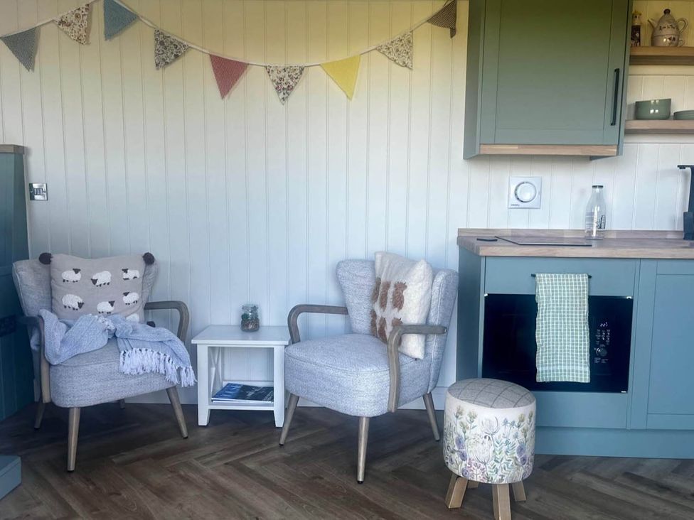 A kitchen with chairs and a table at Peaceful Shepherd Hut near Clovelly